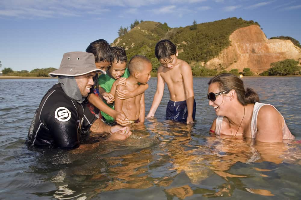 Young Maori extended family collect shellfish, Northland