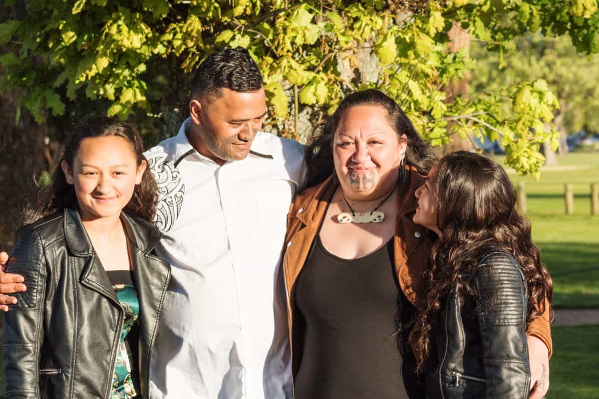 Portrait Of A Young Maori Family Taken Outdoors In A Park Setting
